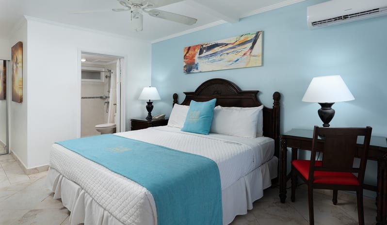 Superior Garden View bedroom with king bed, desk area, and adjoining bathroom at The Club Barbados Resort & Spa by Kenwood Travel
