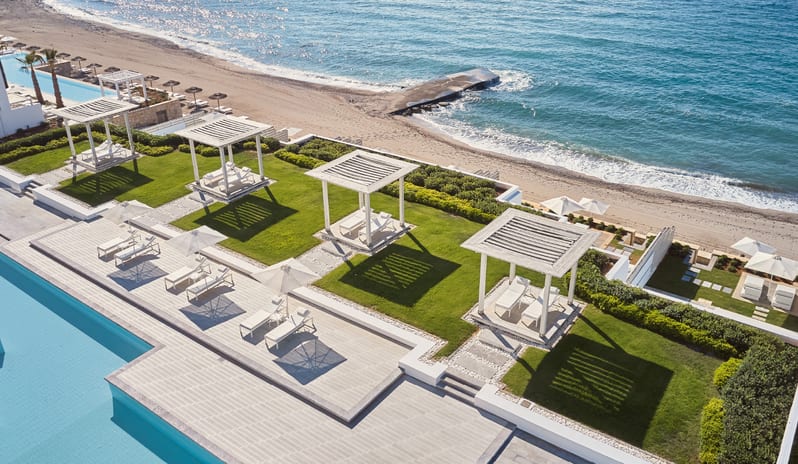 Swim-up Guestroom Sea View Aerial view of luxury white resort cabanas and sun loungers on the lawn next to the beach at Grecotel LUXME White by Kenwood Travel