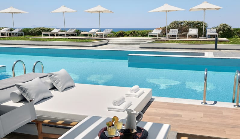 Swim-up Guestroom Sea View Poolside daybed and refreshments next to a resort swimming pool overlooking the ocean at Grecotel LUXME White by Kenwood Travel