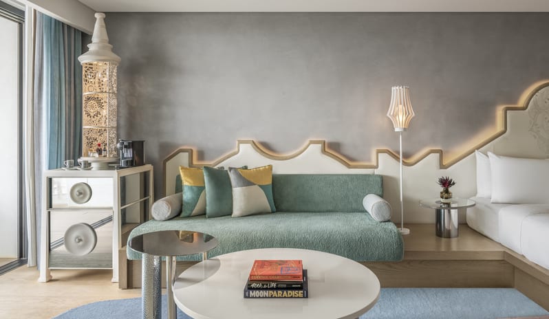 Premium Deluxe Room Modern luxury resort suite living area with a green daybed sofa, decorative wall lighting, and sleek mini bar at W Algarve by Kenwood Travel