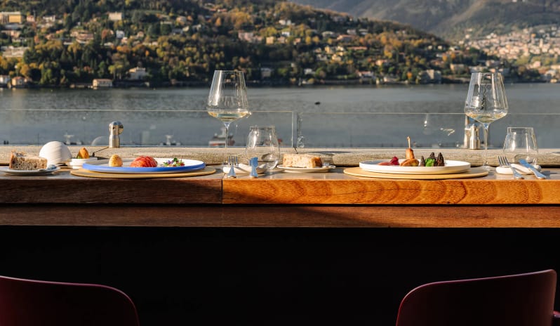 Altariva Bar Rooftop bar counter dining setup with wine glasses and lake views at Palazzo Venezia by Kenwood Travel