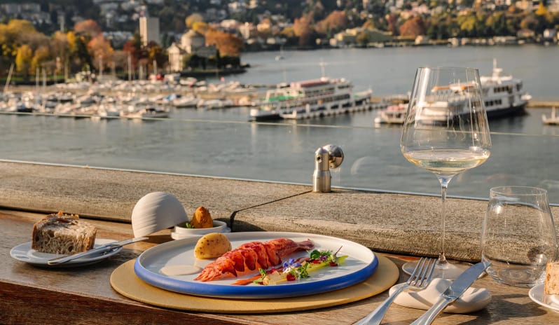 Altariva Bar Plated lobster course and white wine on an outdoor terrace table with scenic lake views at Palazzo Venezia by Kenwood Travel