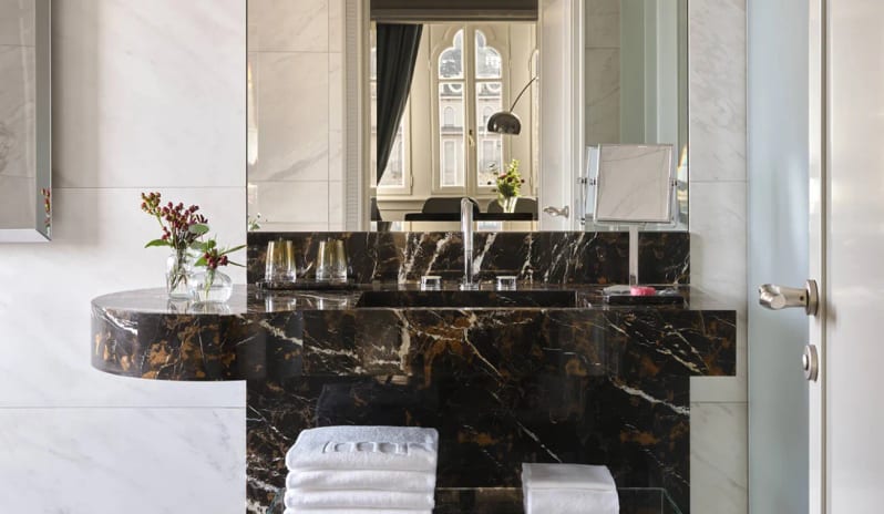 Corner Junior Suite Black veined marble sink vanity and mirror setup at Palazzo Venezia by Kenwood Travel