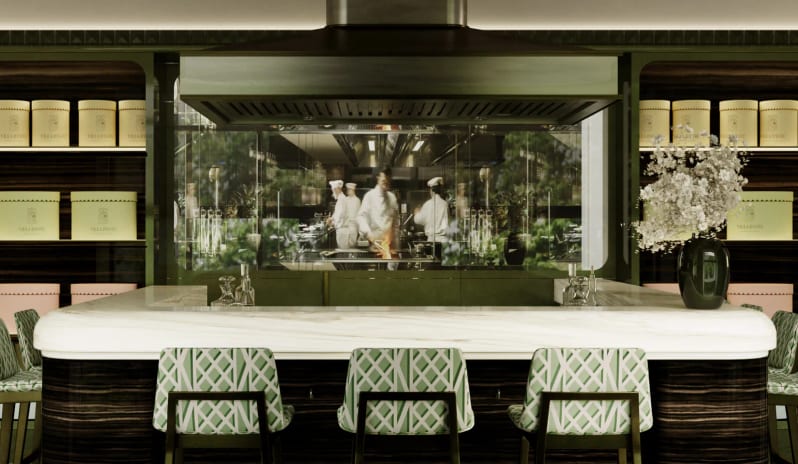 Caffè Cavour bar counter with dark wood base, white marble top, green pattern stool seating, large exhaust hood, and chefs cooking behind glass windows at Palazzo Venezia by Kenwood Travel