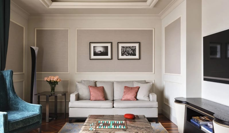 Suite Living room seating area with sofa, velvet armchair, and coffee table at Palazzo Venezia by Kenwood Travel
