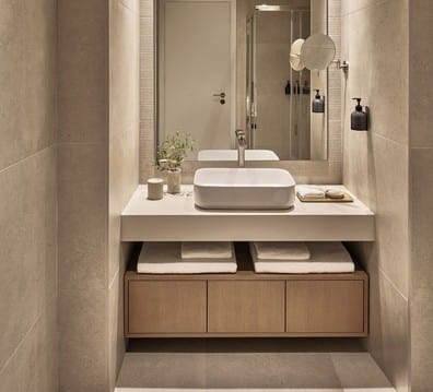 Superior Double Pool View Minimalist hotel bathroom vanity with a vessel sink and folded towels Ikos Olivia by Kenwood Travel