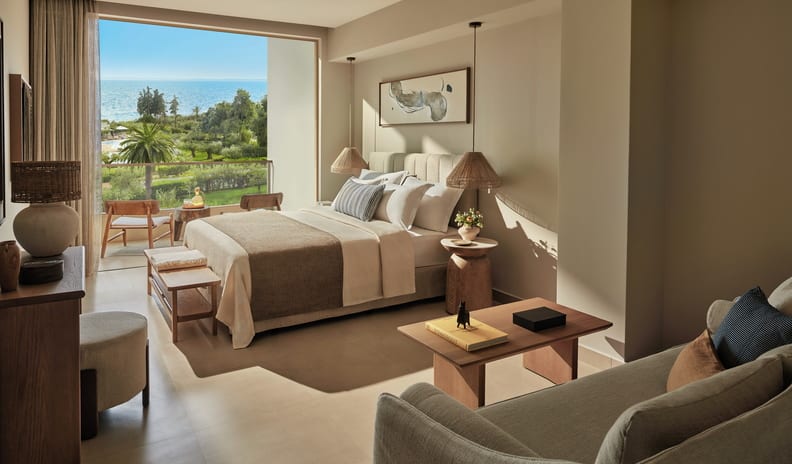 Superior Double Pool View Oceanfront hotel room with a balcony and lounge seating Ikos Olivia by Kenwood Travel