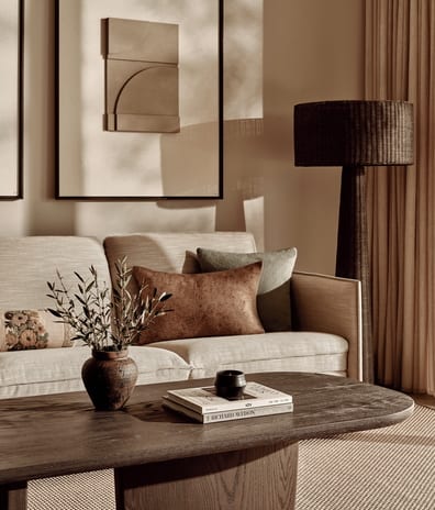 Deluxe Three Bedroom Suite Private Garden Pool View Earthy modern living room setup with wooden coffee table and abstract wall art at Ikos Kissamos by Kenwood Travel