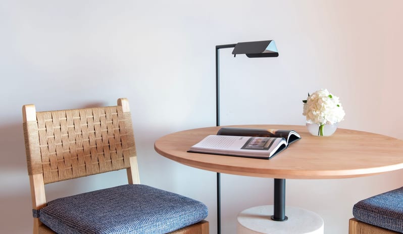 Citadel Two Bedroom Family Resort View Modern resort suite workspace showcasing a light wood pedestal table, contemporary black reading light, and woven accent seating at Ritz Carlton Tenerife Abama by Kenwood Travel
