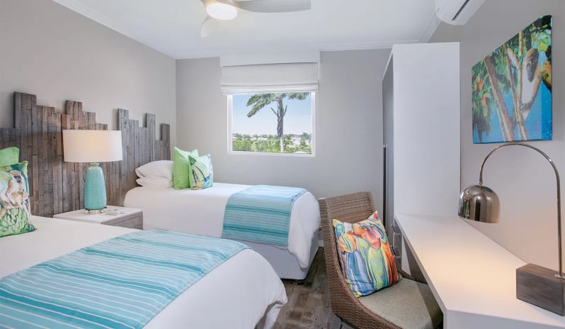 Luxury Suite Three Bedroom Ocean Front Coastal hotel bathroom interior displaying a white floating sink vanity, plush white towels, bright backlit mirror, and a seamless tiled walk-in shower at Sea Breeze Beach House by Kenwood Travel