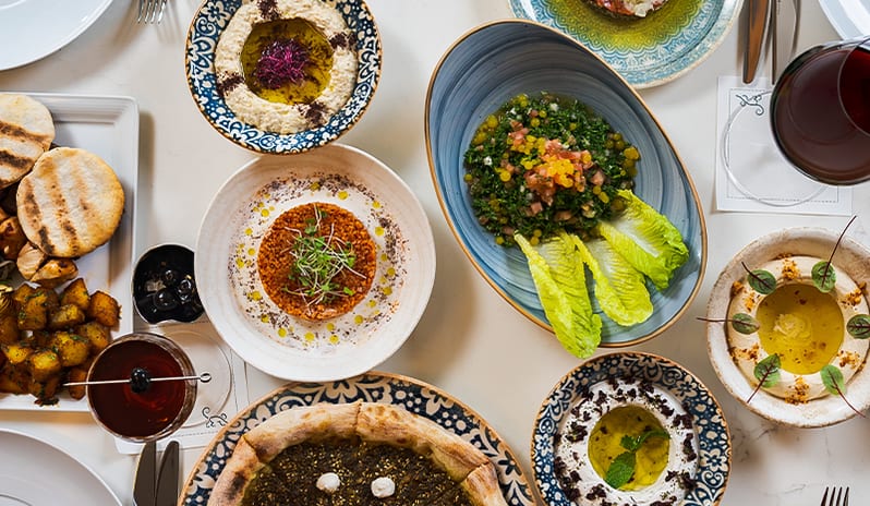 Amara Top-down view of a colorful Middle Eastern mezze platter table setting at Blue Monkey Hotel & Beach Club by Kenwood Travel