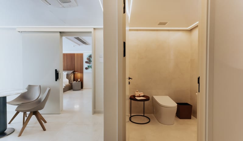 Blue Monkey Signature One Bedroom Suite Minimalist suite layout showing a modern powder room alongside an open living space with sliding doors leading to the bedroom at Blue Monkey Hotel & Beach Club by Kenwood Travel