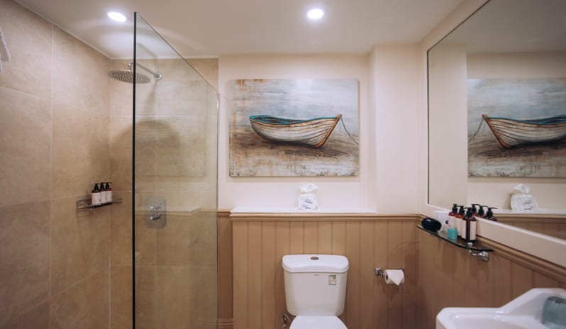 Hillside Luxury Room Luxury hotel suite bathroom featuring a walk-in shower enclosure, large mirror, and coastal decor  at Blue waters Resort & spa by Kenwood Travel