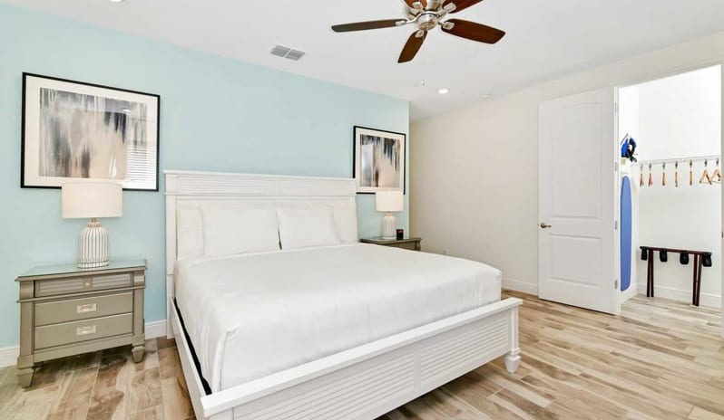 Four Bedroom Villa Bright master bedroom featuring a white panel king bed and light blue accent wall at Margaritaville Resort Orlando by Kenwood Travel