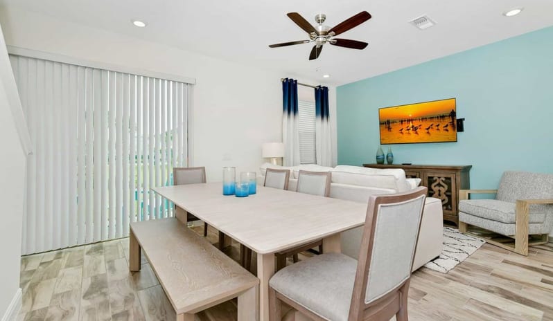 Four Bedroom Villa Bright coastal dining room and living space with light blue accent wall at Margaritaville Resort Orlando by Kenwood Travel