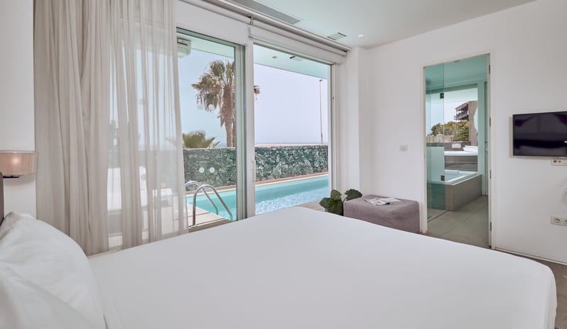 Divine Mar Luxury bedroom with direct outdoor private pool access through large glass doors at Domes Baobab by Kenwood Travel