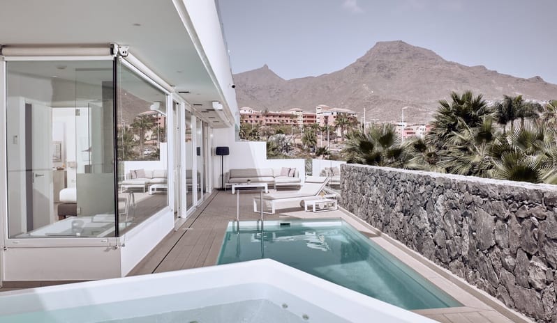Divine Mar Modern resort villa patio with private pool and hot tub against a mountain backdrop at Domes Baobab by Kenwood Travel