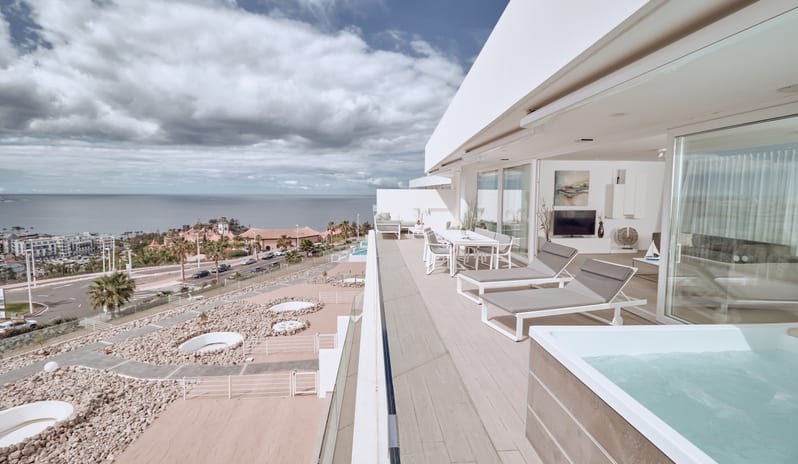 Serenity Allegra High-end apartment balcony with private hot tub, sleek outdoor furniture, and panoramic views of the sea and surrounding coastal resort at Domes Baobab by Kenwood Travel