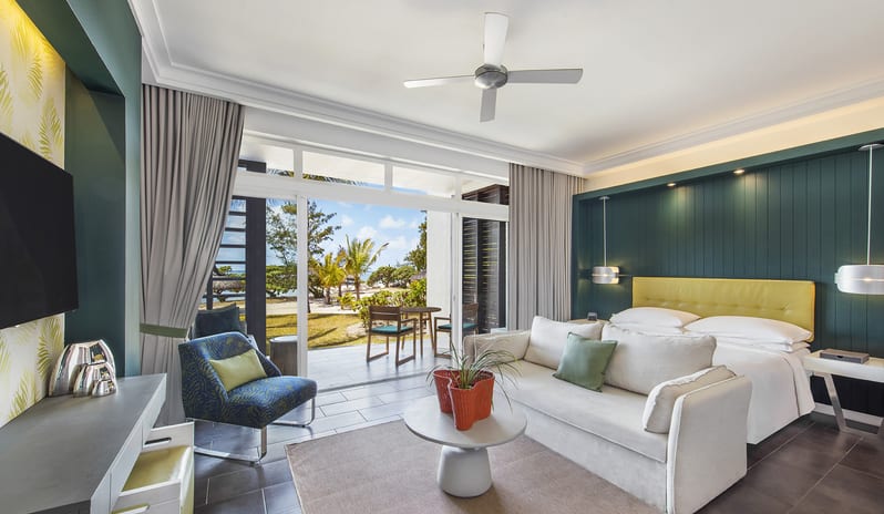 Junior Suite Beach Front king bed, sofa lounge, and sliding glass doors opening to a terrace with ocean views at Long Beach Mauritius by Kenwood Travel