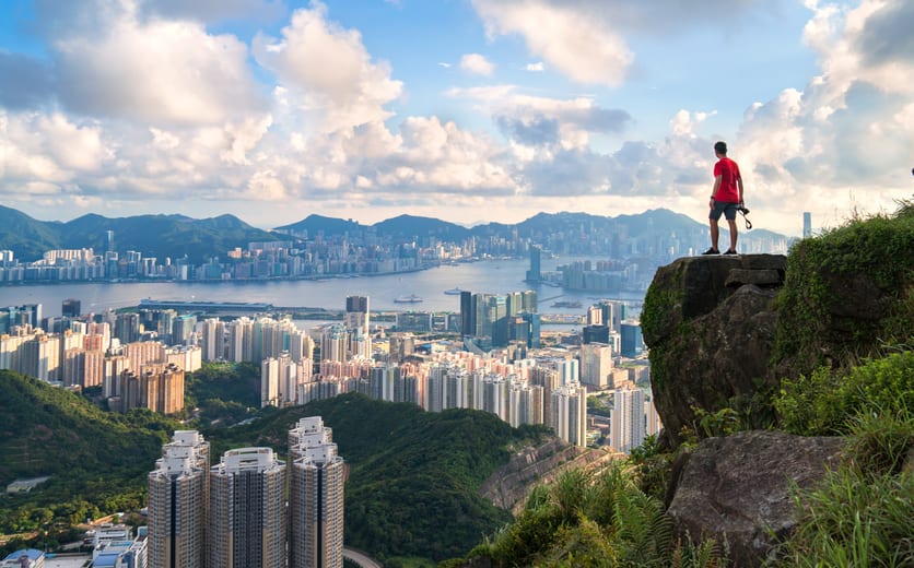photographer standing on the top of Cliff above Hong kong cityscape.jpg