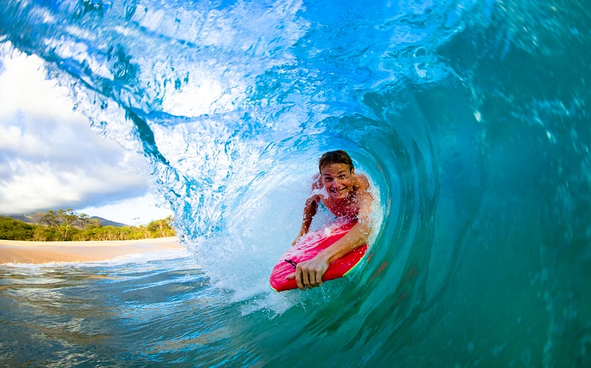 shutterstock_102092515 - Youthful young man Boogie Boarding Blue Wave.jpg